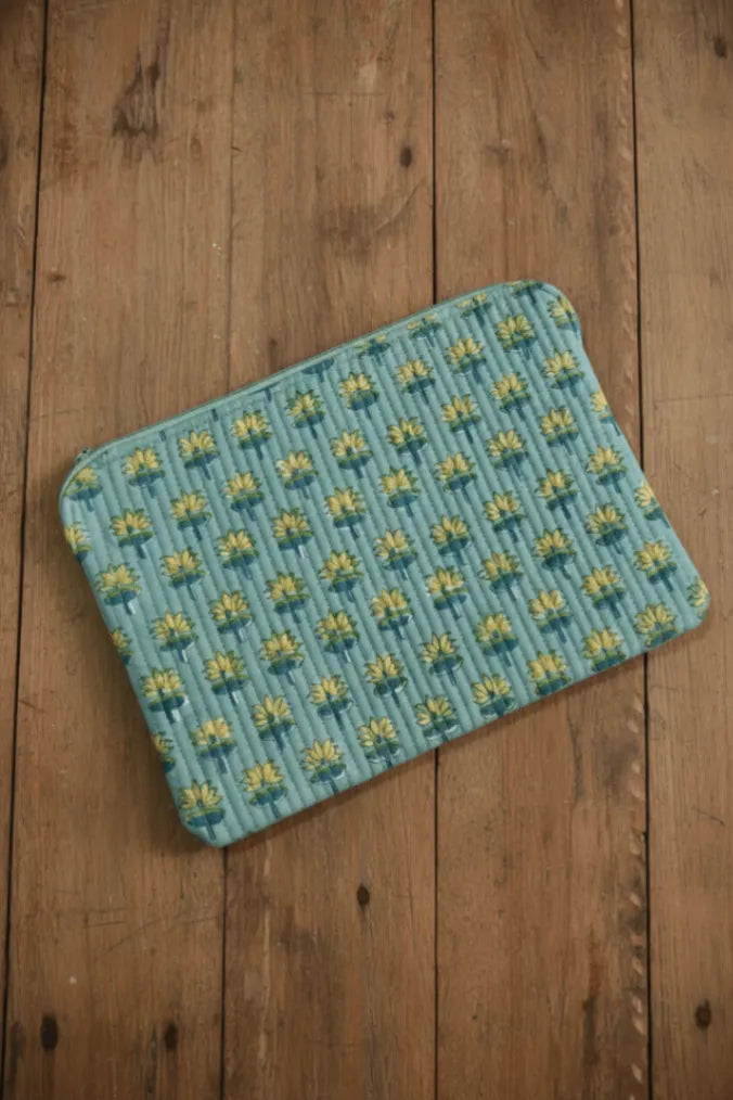 Teal Laptop Sleeve with yellow pattern on a wooden floor
