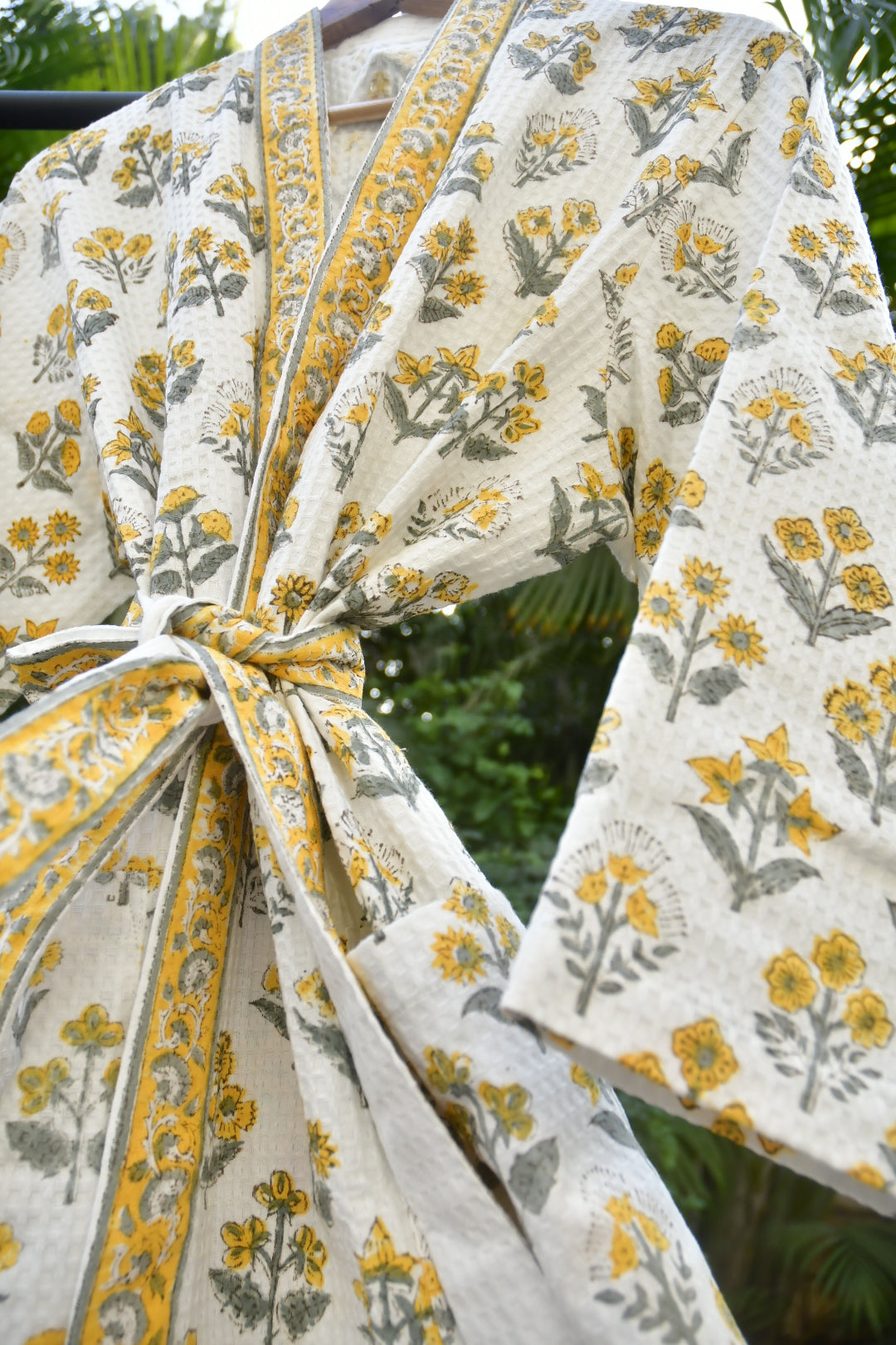 White fabric with yellow and gray floral patterns, possibly a curtain or tablecloth.