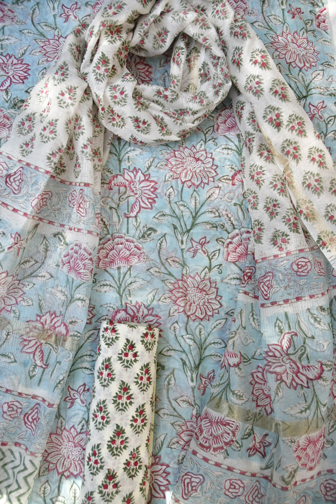 Floral patterned fabric with pink and green flowers on a light blue background