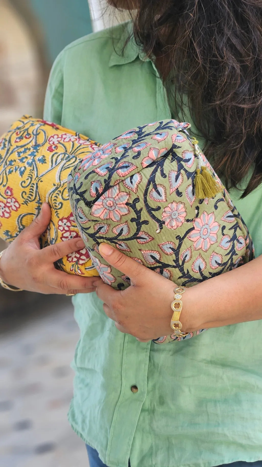 Person holding a colorful floral-patterned clutch bag