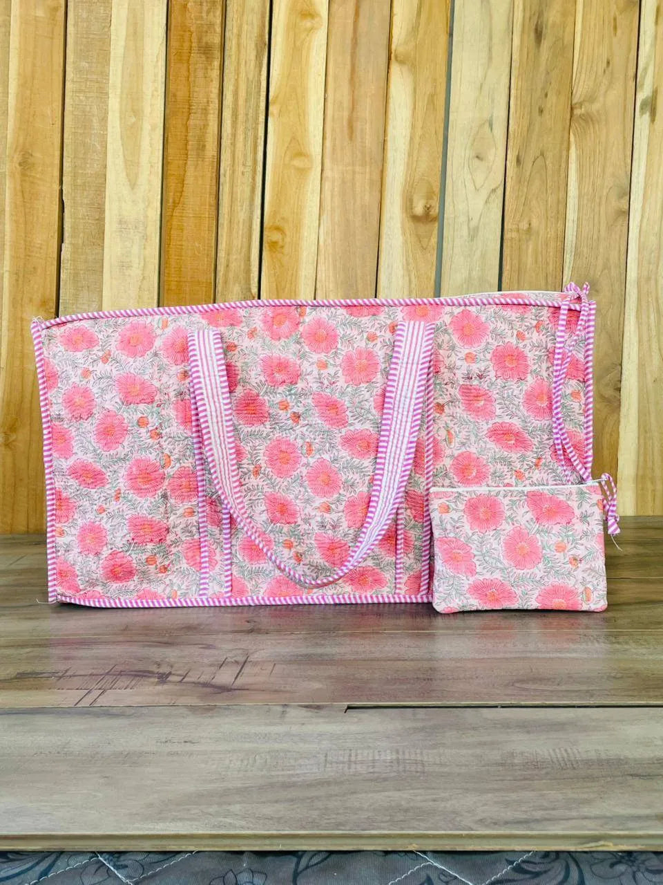 Floral patterned bag with pink trim on a wooden surface