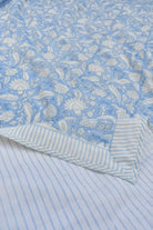 Floral patterned fabric with a striped border on a blue background