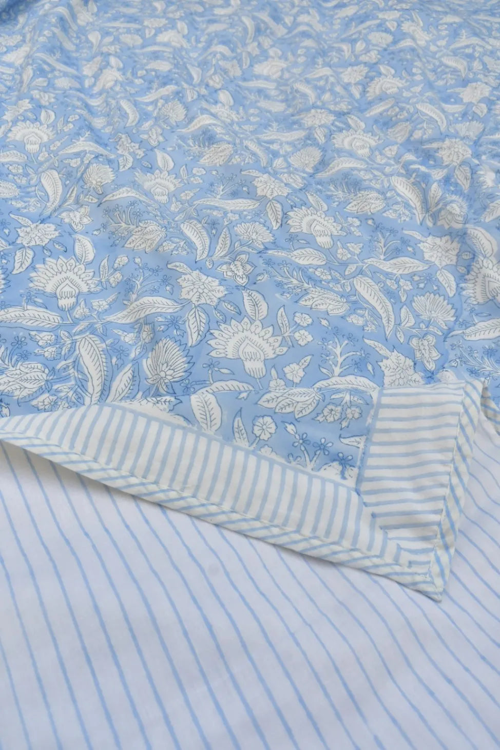Floral patterned fabric with a striped border on a blue background