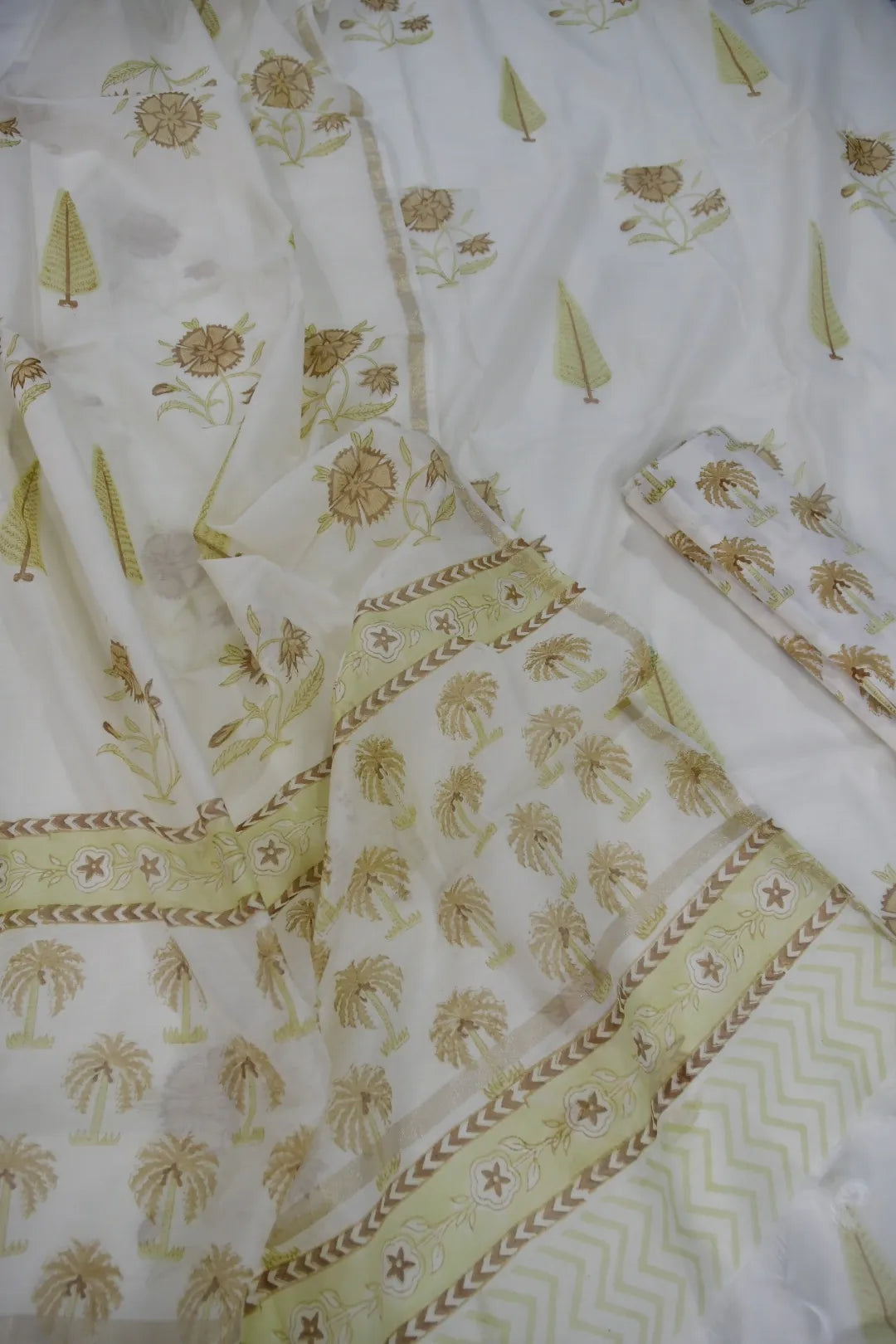 White fabric with green floral patterns and embroidery