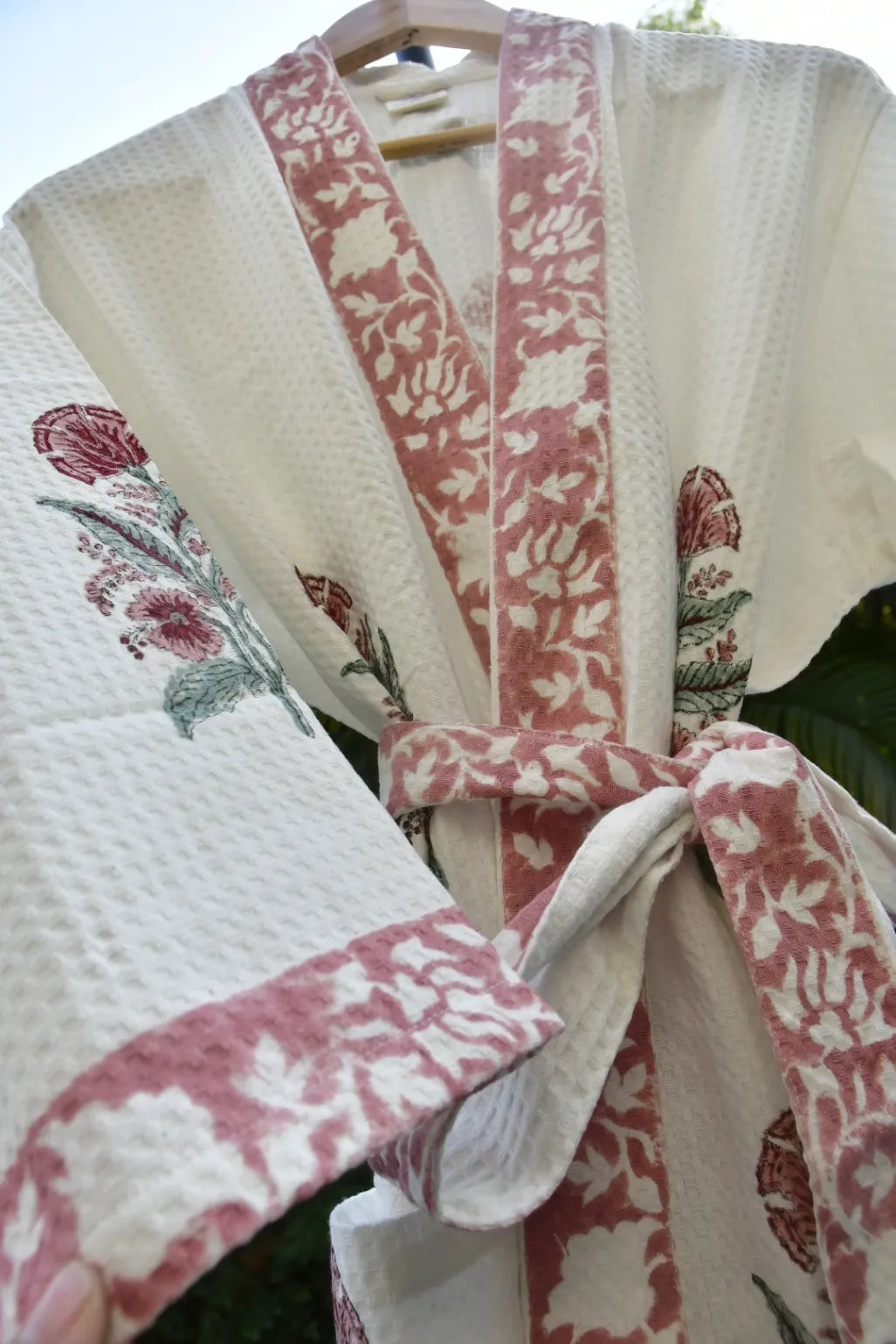 Close-up of a kimono with floral patterns and a pink belt.