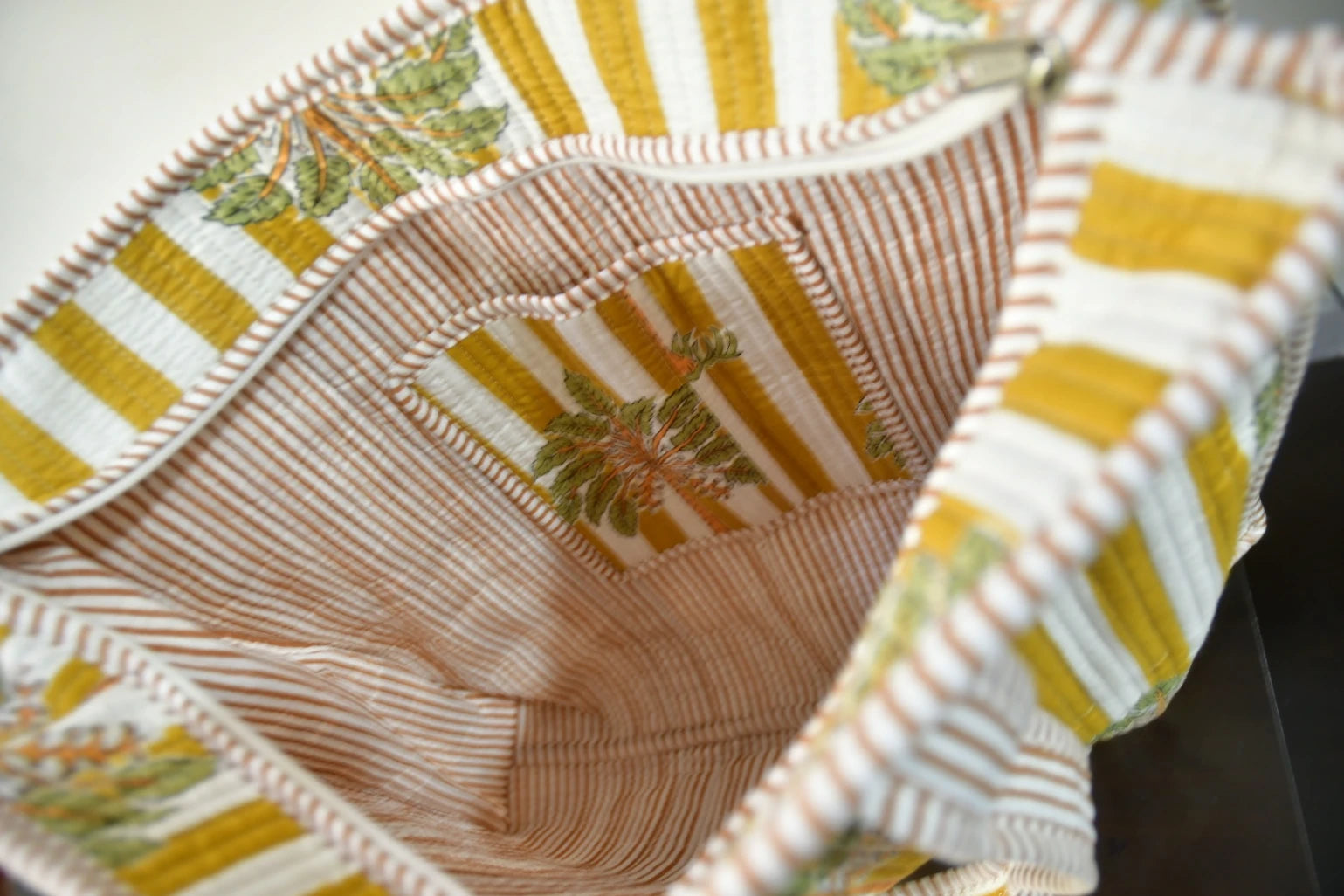 Close-up of a quilt with yellow, white, and brown patterns