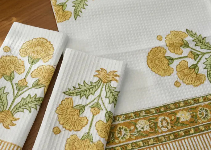 Set of embroidered towels with floral patterns on a wooden surface
