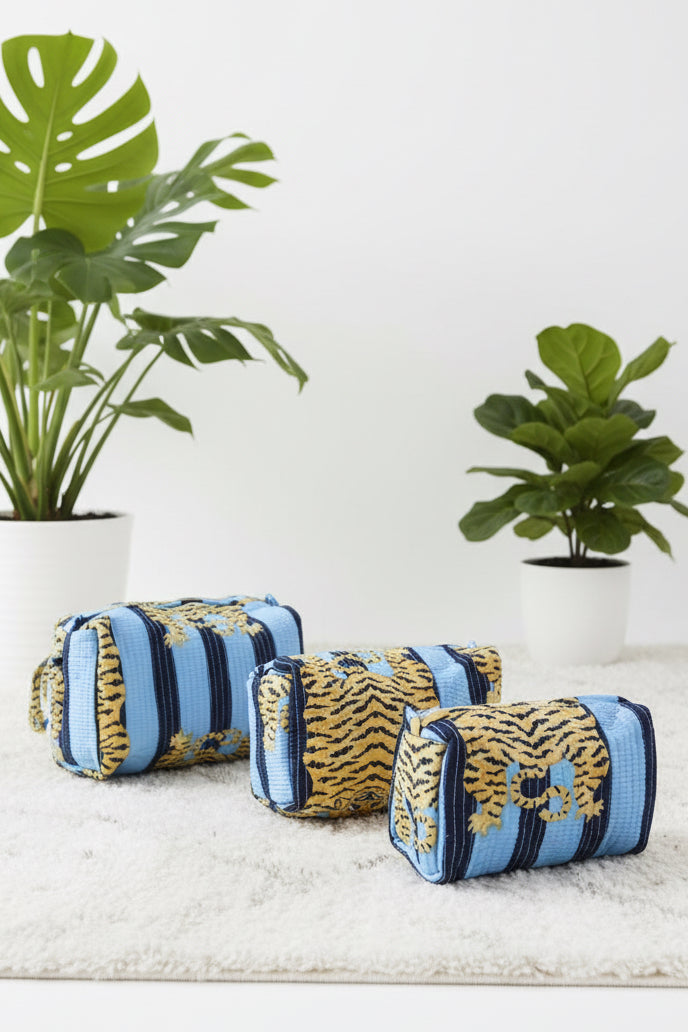 Decorative pillows with blue and gold patterns on a white surface.
