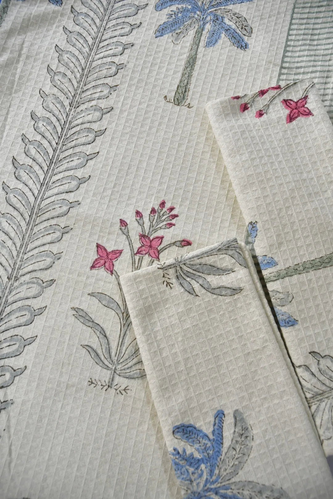 Close-up of fabric with floral and leaf patterns on a textured background cotton and bath towel set