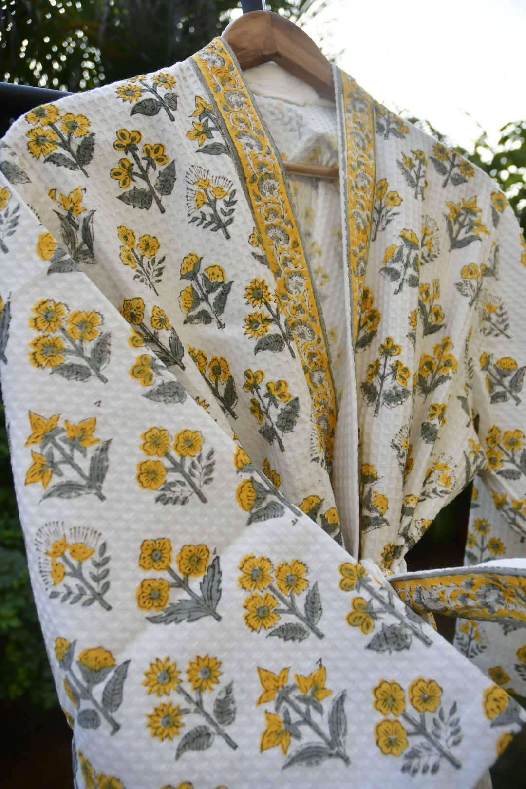 Floral patterned fabric with yellow and gray flowers on a white background