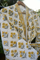 Floral patterned fabric with yellow and gray flowers on a white background