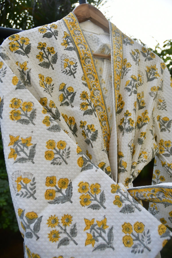 Floral patterned fabric with yellow and gray flowers on a white background