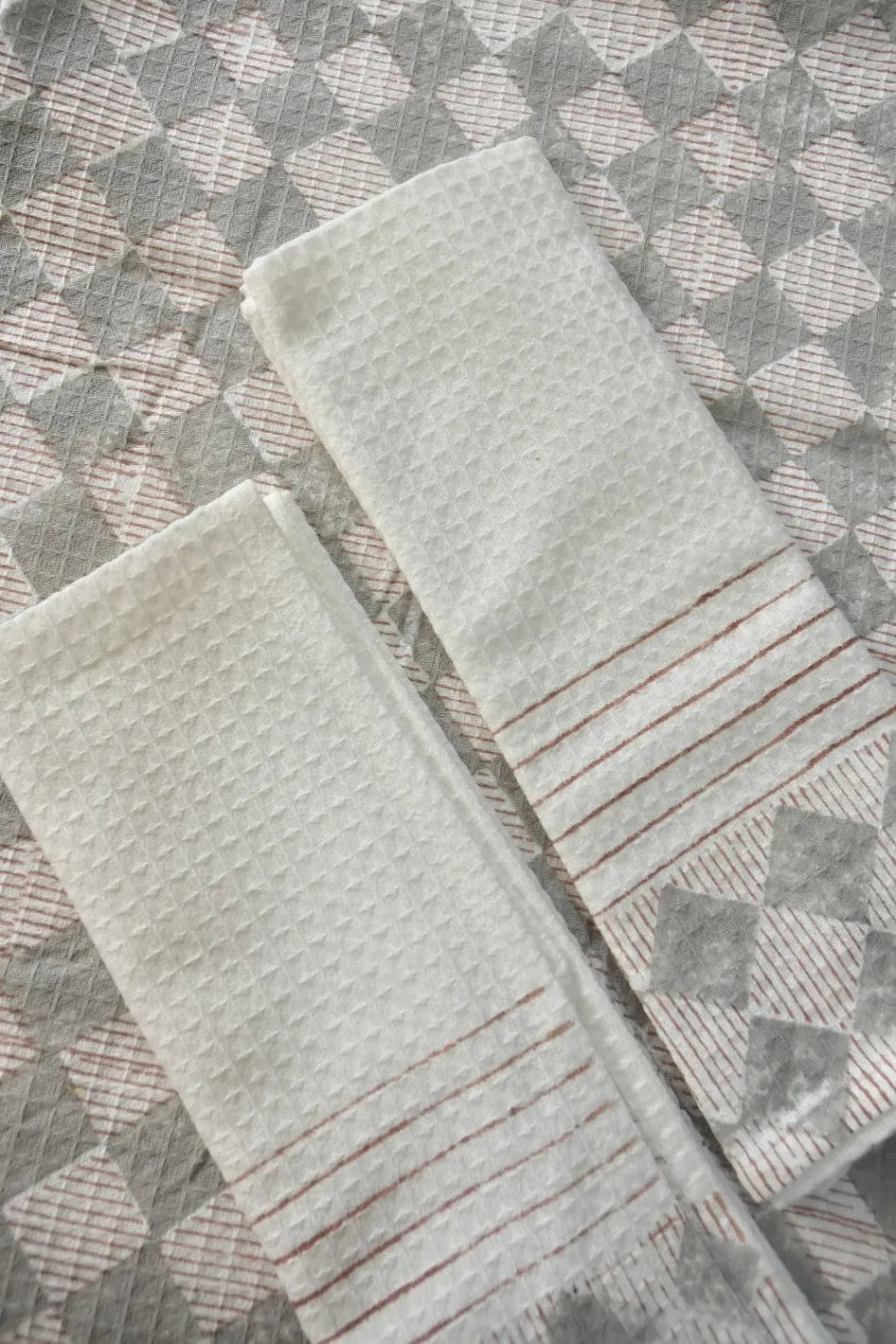 Two textured towels on a patterned surface