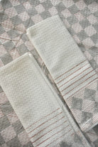 Two textured towels on a patterned surface