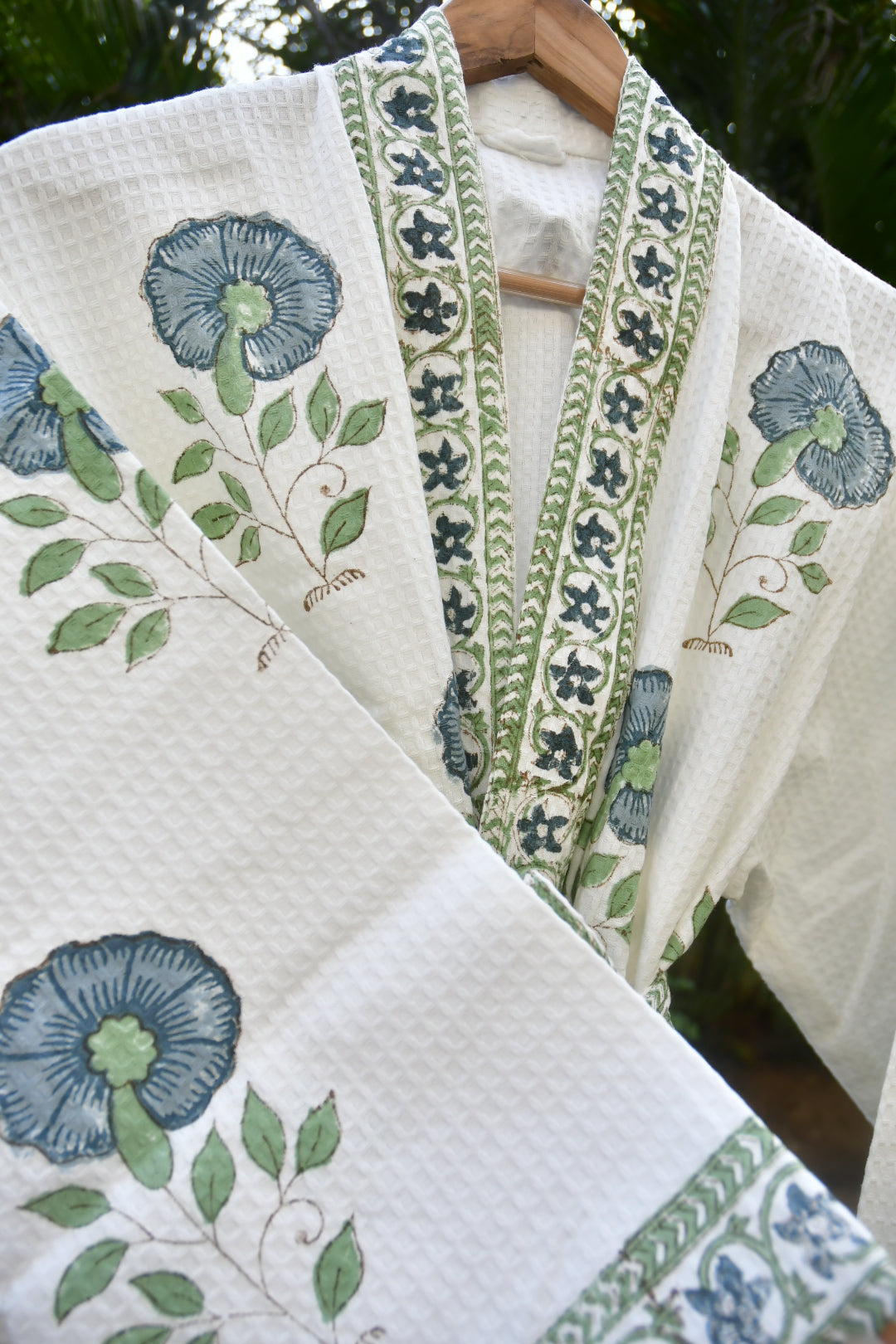 Embroidered fabric with floral and leaf patterns on a white background