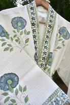 Embroidered fabric with floral and leaf patterns on a white background