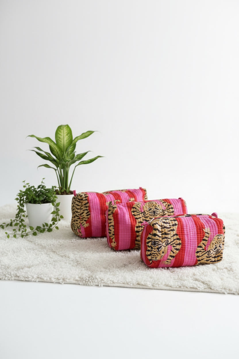 Pink with tiger patterned bags on a white bed