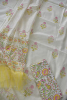 White fabric with colorful floral patterns and yellow accents